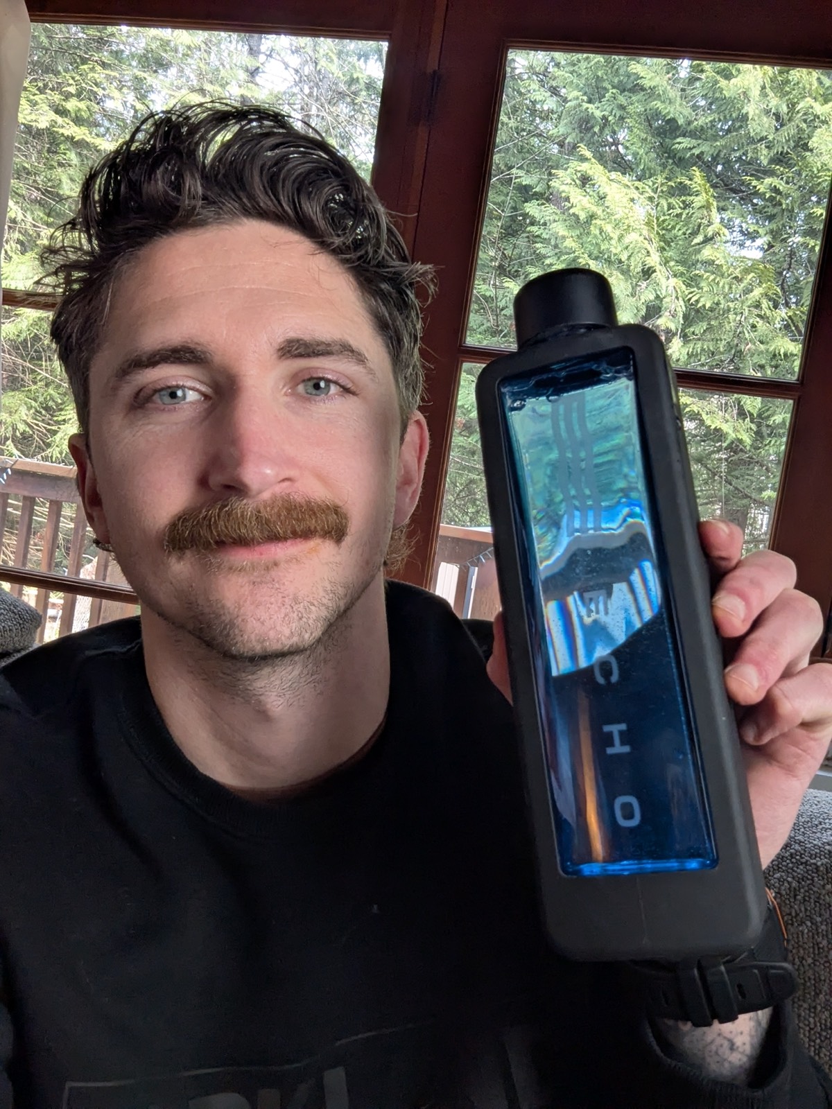 an echo hydrogen water bottle next to his face