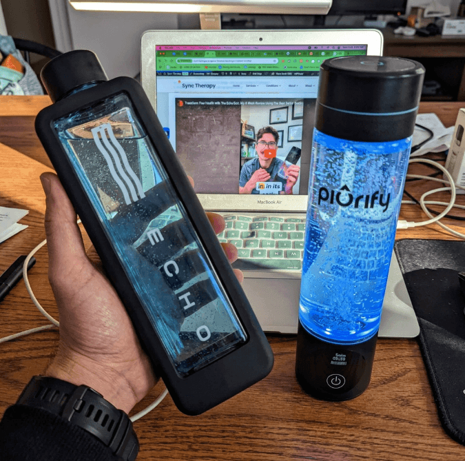 Echo Flask app displayed on phone screen next to the Echo Flask hydrogen water bottle