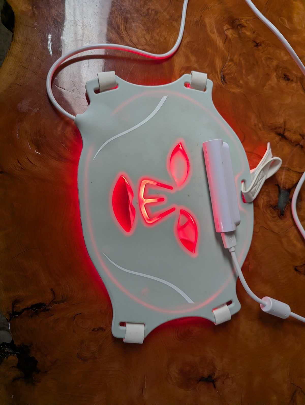 holding a red light therapy mask 