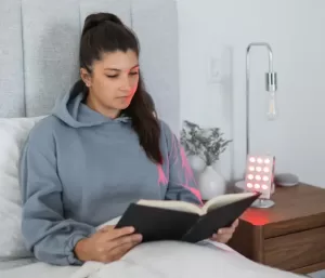 a woman reading the review of the orion edge 2.0 to help improve sleep while reading